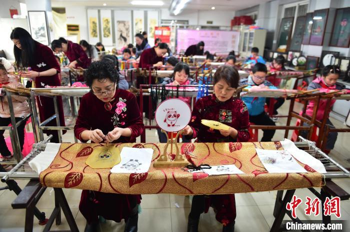 江西省級(jí)非遺豫章繡傳承人手把手指導(dǎo)小學(xué)生繡制2022年北京冬奧會(huì)吉祥物“冰墩墩”形象?！∮髟屏?攝