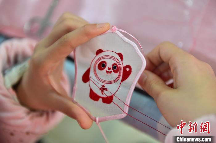 圖為一名小學(xué)生正在繡制2022年北京冬奧會(huì)吉祥物“冰墩墩”形象。　喻云亮 攝