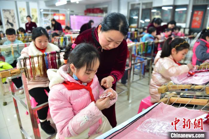 江西省級(jí)非遺豫章繡傳承人手把手指導(dǎo)小學(xué)生繡制2022年北京冬奧會(huì)吉祥物“冰墩墩”形象?！∮髟屏?攝