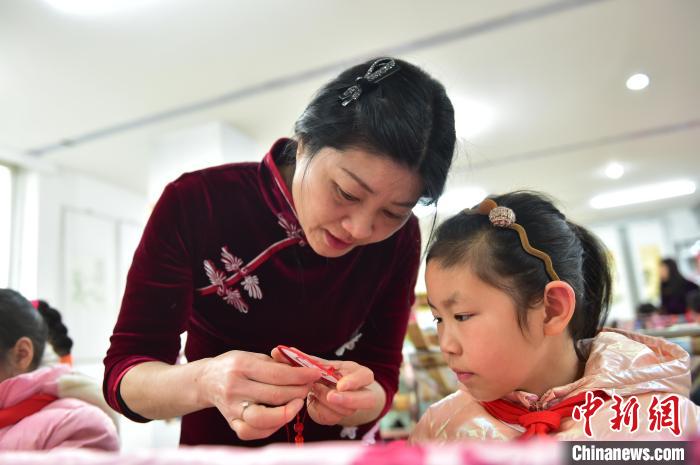 江西省級(jí)非遺豫章繡傳承人手把手指導(dǎo)小學(xué)生繡制2022年北京冬奧會(huì)吉祥物“冰墩墩”形象?！∮髟屏?攝