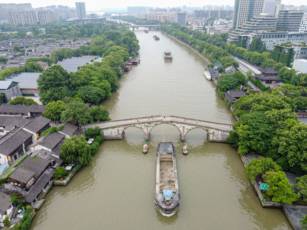 5月27日，一艘貨船駛過京杭大運(yùn)河南端標(biāo)志建筑杭州拱宸橋。(無人機(jī)照片)新華社記者江漢 攝