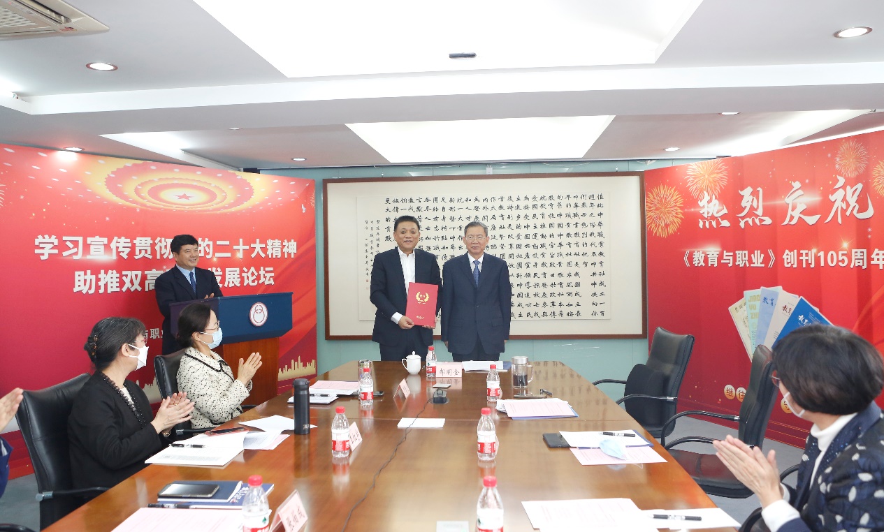 郝明金為《教育與職業(yè)》雜志編委代表陳曉明頒發(fā)聘書。中華職教社供圖