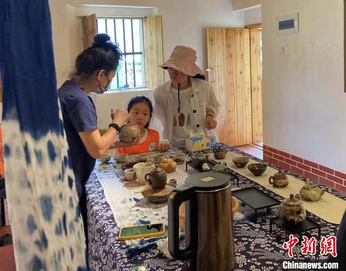 圖為：游客正在咨詢臺(tái)灣柴燒作品?！∪~秋云 攝