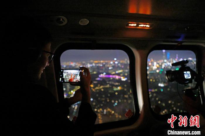 6月3日晚，游客乘坐上海新空直升機有限公司直升機開啟鳥瞰黃浦江空中圓夢之旅，并用手機拍攝城市夜景。　殷立勤 攝