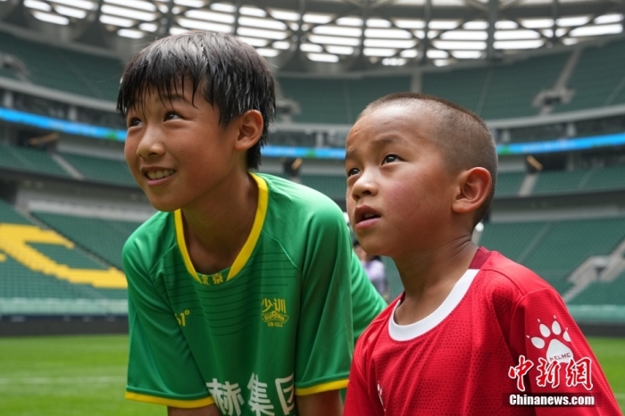圖為北京國安小球員陳小北和7歲的俄金仁增在一起觀看場內播放的紀錄片。<a target='_blank' href='/' _fcksavedurl='/'><p  align=