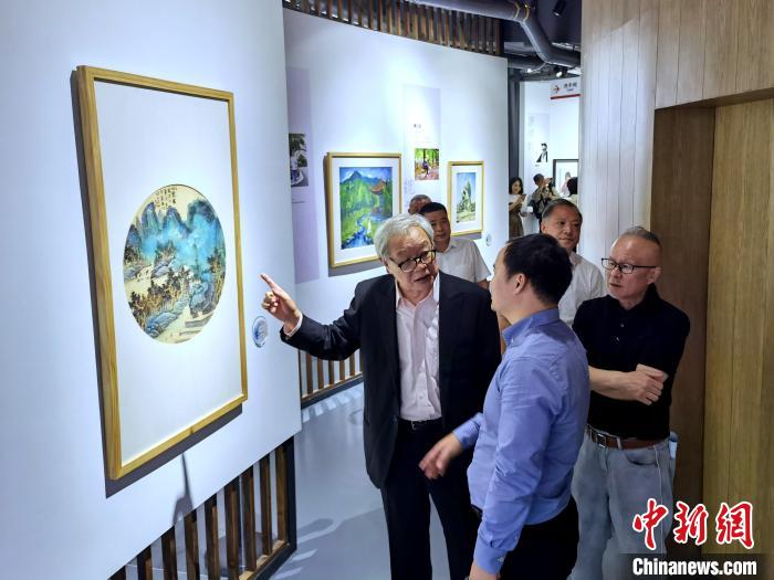 海峽兩岸藝術(shù)家畫展上，藝術(shù)家進行藝術(shù)交流?！「毒窜?攝