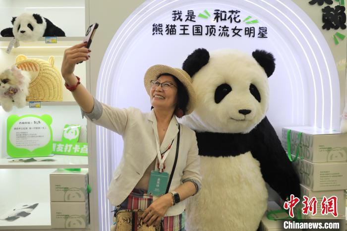 美國華視總裁楊蓮花與大熊貓文創(chuàng)產(chǎn)品合影?！⊥趵?攝