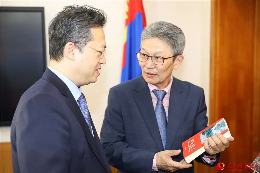其米德策耶（右一）向李峙介紹翻譯成果。人民網(wǎng)記者 霍文攝