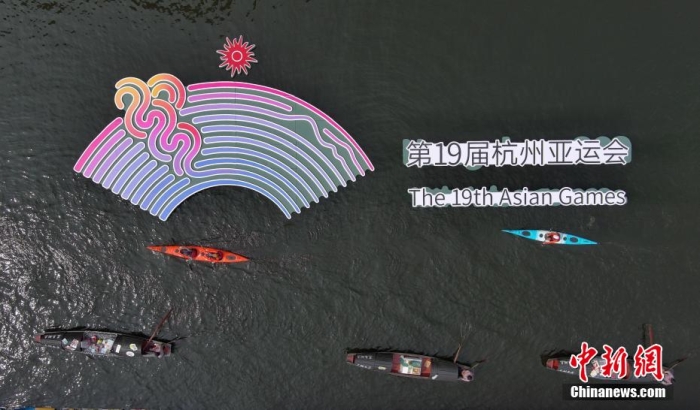 資料圖為烏篷船和皮劃艇從杭州亞運(yùn)會(huì)標(biāo)識(shí)前劃過(guò)。王剛 攝