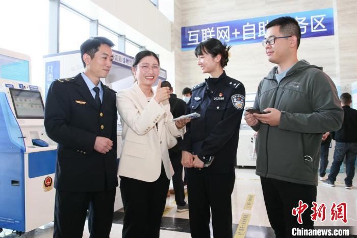 4月10日，安徽合肥，一家運輸企業(yè)負責人在工作人員的指導下，使用小程序辦理車管業(yè)務?！『戏示焦﹫D