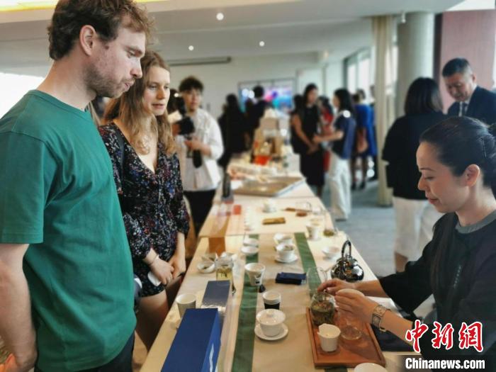 現(xiàn)場觀眾觀看中國展臺(tái)茶藝表演、了解茶文化。　靖樹 攝