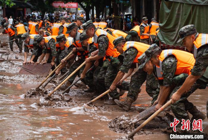 7月4日，萬(wàn)州區(qū)五橋街道，武警官兵清理街道上的淤泥?！∪矫宪?攝
