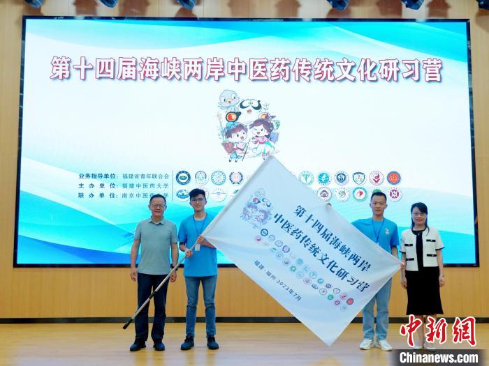 共青團(tuán)福建省委副書記吳雪(右一)、福建中醫(yī)藥大學(xué)黨委副書記林羽(左一)為兩岸學(xué)生代表頒授營(yíng)旗?！≡S燁婷 攝