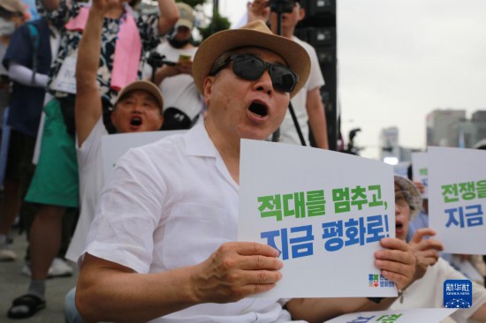 7月22日，在韓國首爾，人們手舉標(biāo)語參與反戰(zhàn)游行。新華社發(fā)（楊暢 攝）