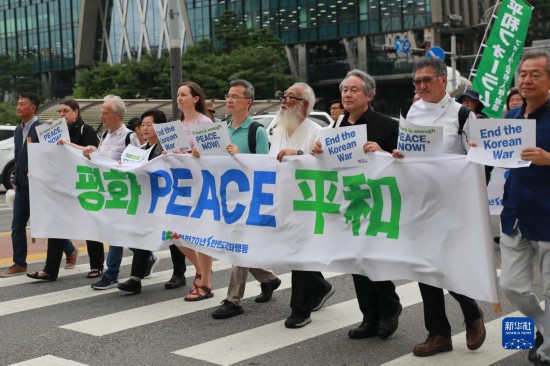 7月22日，在韓國首爾，人們手舉標(biāo)語參與反戰(zhàn)游行。新華社發(fā)（楊暢 攝）