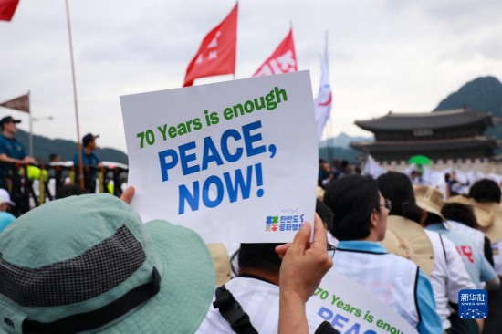 7月22日，在韓國首爾，人們手舉標(biāo)語參與反戰(zhàn)游行。新華社發(fā)（楊暢 攝）