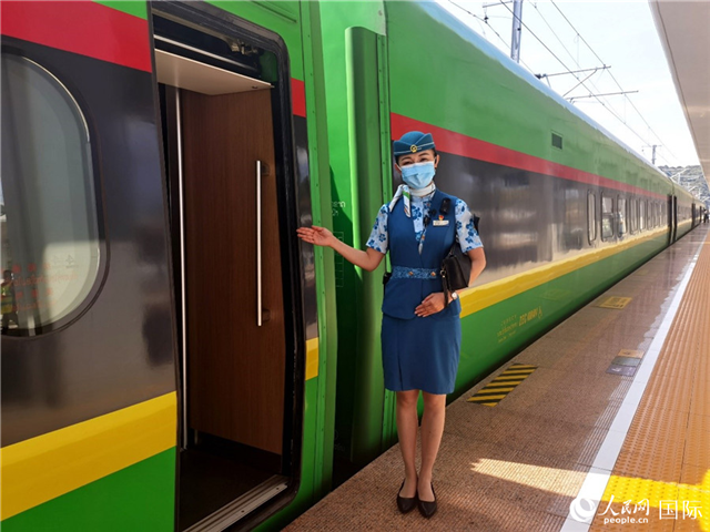 趙瑩靜站在“復(fù)興號”國際旅客列車車廂門口歡迎旅客上車。人民網(wǎng) 杜明明攝