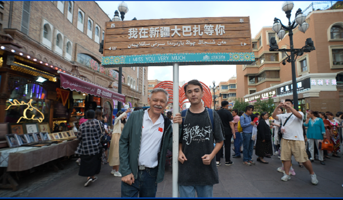 潘維廉和維吾爾族青年伊木蘭“打卡”大巴扎。主辦方供圖