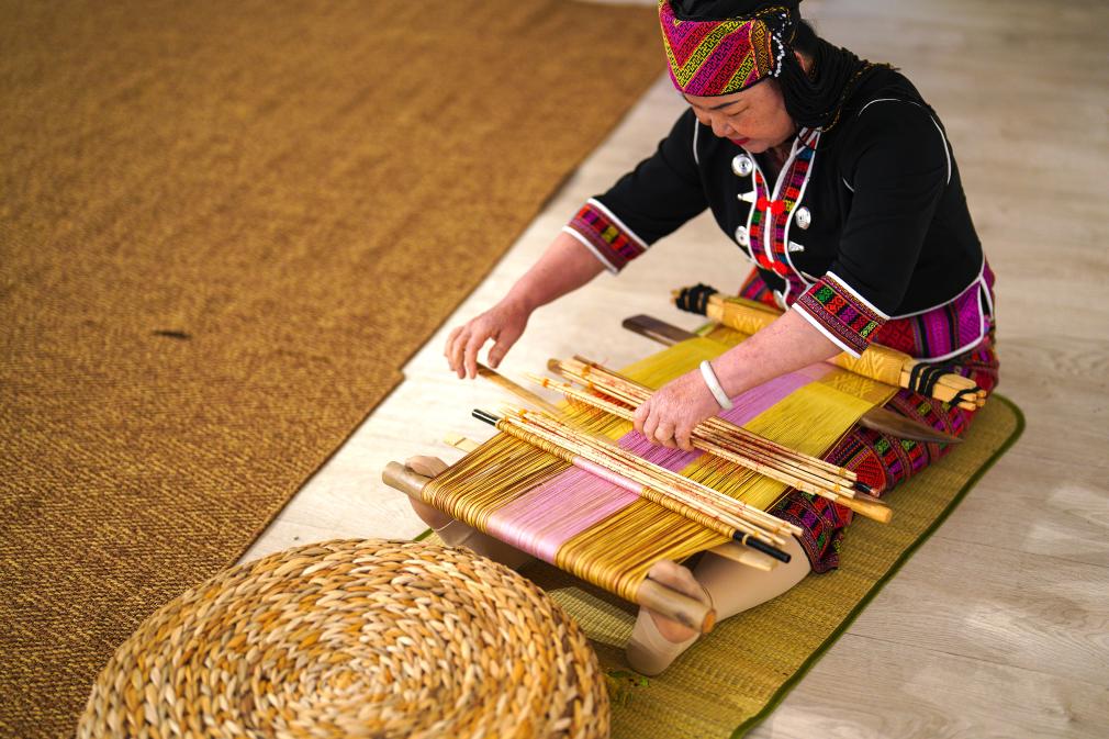 4月17日，黎族傳統(tǒng)紡染織繡技藝國(guó)家級(jí)代表性傳承人劉香蘭在2023年意大利米蘭設(shè)計(jì)周上展示黎錦織造技藝。新華社發(fā)