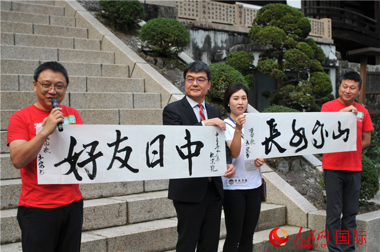 東京中國(guó)文化中心主任羅玉泉展示其為本次活動(dòng)書寫的題詞“中日友好，山高水長(zhǎng)”。人民網(wǎng) 蔣曉辰攝
