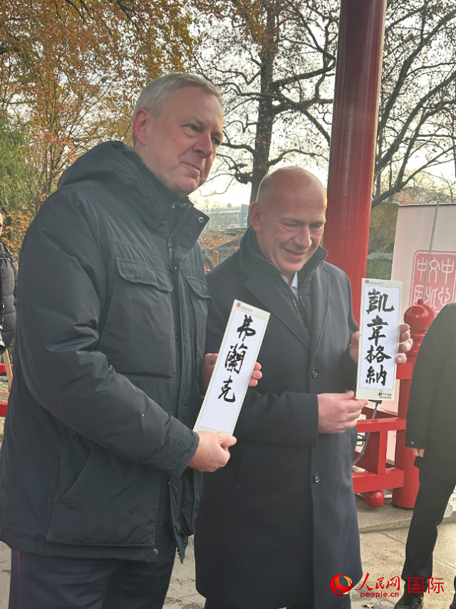 柏林市長(zhǎng)韋格納（右）、動(dòng)物園監(jiān)事會(huì)主席布魯克曼（左）手持中國(guó)文化中心工作人員現(xiàn)場(chǎng)手書的中文名字。人民網(wǎng)記者 徐馨攝