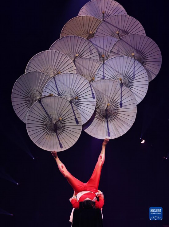 12月8日，演員在法國(guó)巴黎舉行的中國(guó)雜技“奇妙之夜”演出上表演《蹬傘》。新華社記者 高靜 攝