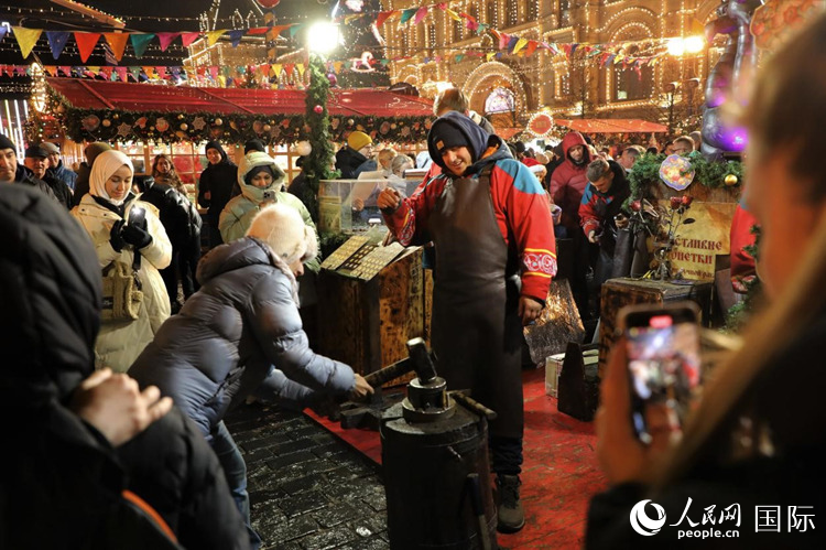游客在新年集市上體驗(yàn)制作紀(jì)念幣。人民網(wǎng)記者 隋鑫攝