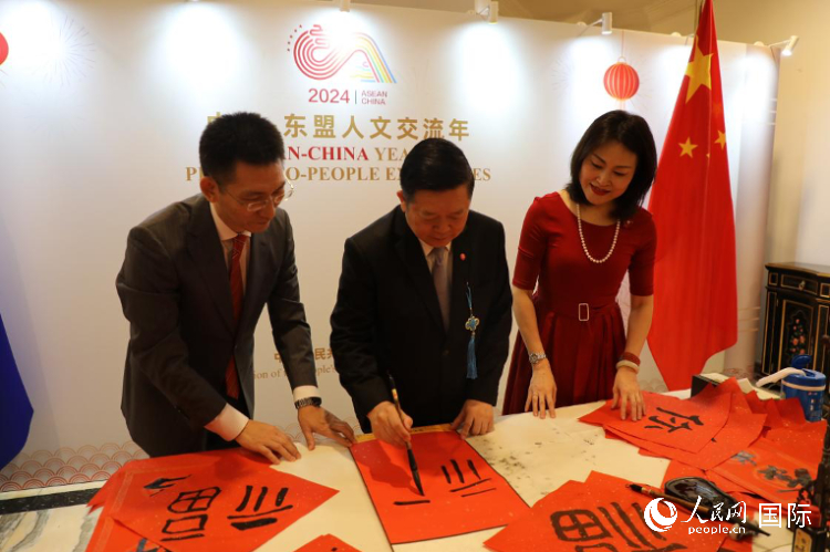 東盟秘書長高金洪（中）在活動現(xiàn)場寫福字。人民網(wǎng)記者曹師韻攝