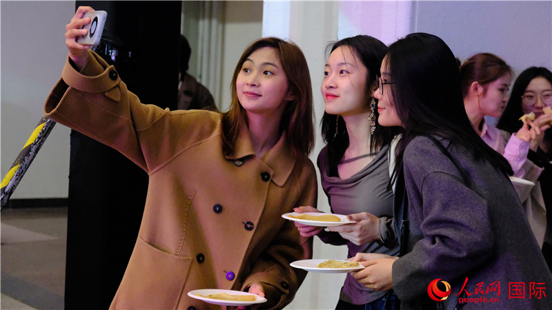 中國觀眾在現(xiàn)場品嘗“謝肉節(jié)”節(jié)日美食——煎薄餅。人民網(wǎng) 褚夢琦攝