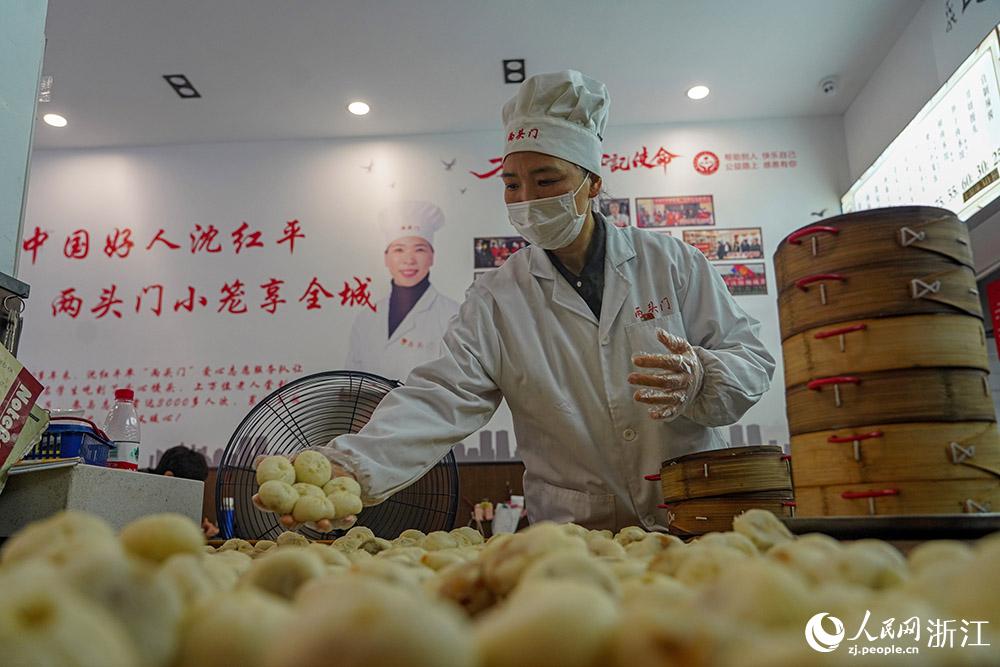 3月31日，在浙江省嵊州市甘霖鎮(zhèn)，嵊州小吃從業(yè)者沈紅平把蒸熟的小籠包晾涼，打包冷藏售賣(mài)。人民網(wǎng) 章勇濤攝