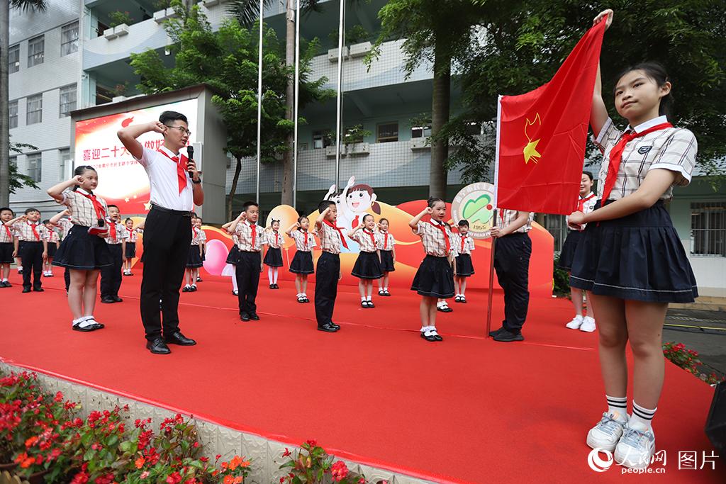 5月31日，在廣西壯族自治區(qū)南寧市民主路小學(xué)，學(xué)校大隊輔導(dǎo)員帶領(lǐng)少先隊員呼號。人民網(wǎng)記者 嚴(yán)立政攝