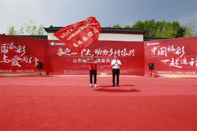 為媒體采風(fēng)團(tuán)授旗。 山東省福彩供圖