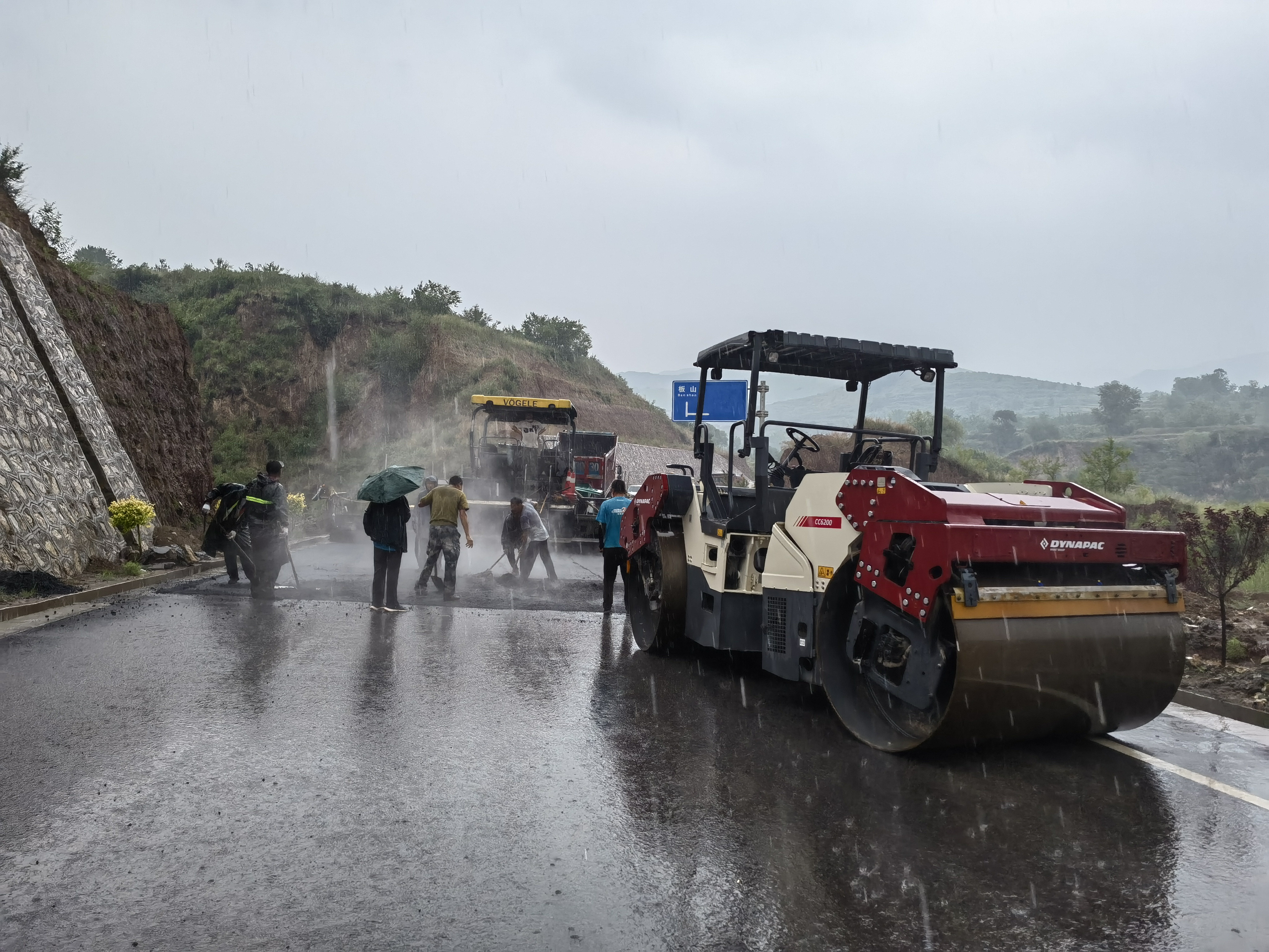 路橋工人在大雨中搶修道路。李華英 攝