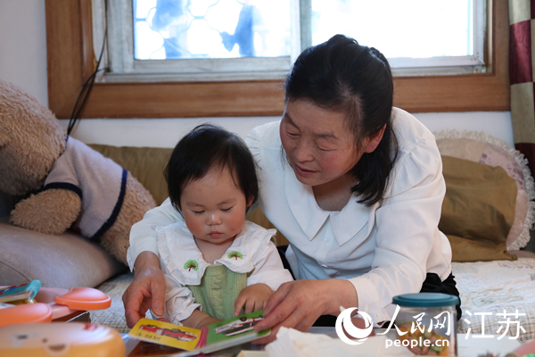 王繼蓮帶孫女看童書(shū)。人民網(wǎng) 冷金明攝