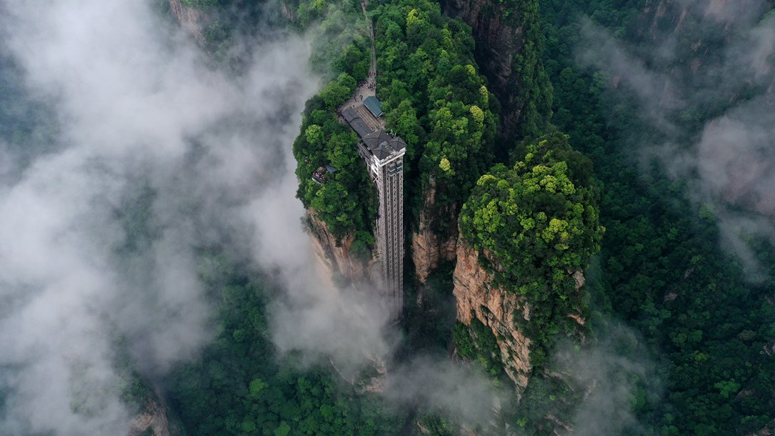 位于張家界武陵源景區(qū)的百龍?zhí)焯蓁偳对谠旗F繚繞的峰林間，雄偉壯觀。吳勇兵攝