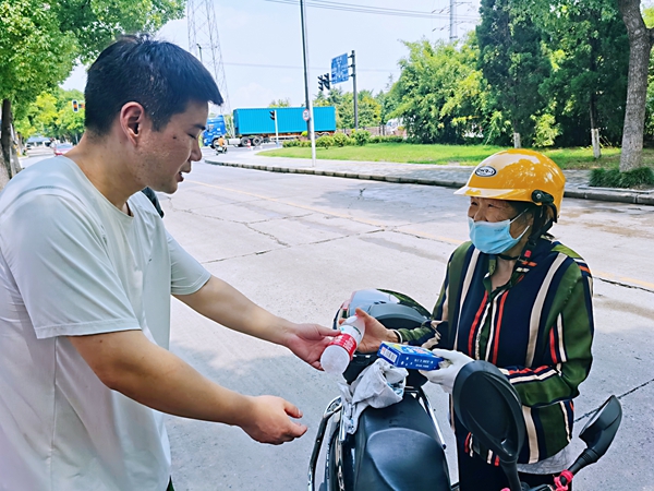 何超為過路的老人送上礦泉水和冷飲。人民網(wǎng)記者 王繼亮攝