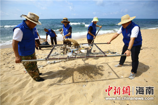 環(huán)保志愿者用篩網(wǎng)“淘”出海灘上的垃圾。