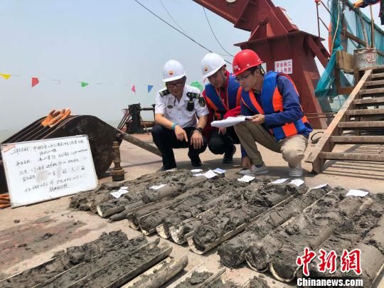 圖為勘察設(shè)計(jì)人員與海事局工作人員查看巖芯情況?！∥赫?攝