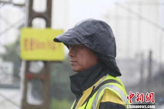 蘭州西工務(wù)段蘭州線路車間防護(hù)員雨中巡查?！⊥豕廨x 攝