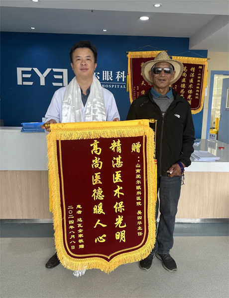 達瓦老人向吳四華（左）贈送錦旗。受訪者供圖