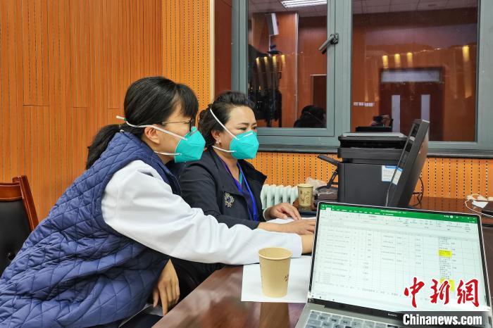 8月9日，楊蘇喬(左)在拉薩方艙醫(yī)院指揮部讀取艙內(nèi)患者胸部CT。　受訪者供圖