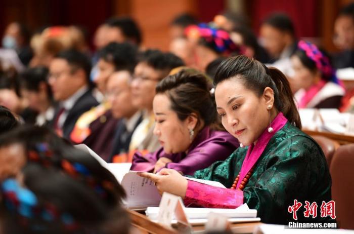 1月5日，次旦卓嘎(右一)在拉薩參加西藏自治區(qū)第十一屆人民代表大會(huì)第五次會(huì)議第二次全體會(huì)議。西藏自治區(qū)人大代表次旦卓嘎來(lái)自日喀則市定日縣，定日縣被稱(chēng)為“洛諧故鄉(xiāng)”，作為西藏民間歌舞，洛諧已被列入中國(guó)國(guó)家非物質(zhì)文化遺產(chǎn)項(xiàng)目名錄，這是集歌、舞、樂(lè)、彈唱于一體的綜合藝術(shù)形式。參加完西藏2022年新年音樂(lè)會(huì)的次旦卓嘎告訴記者，每年參加的基層演出可達(dá)80場(chǎng)，“我希望用最純粹的方式，把最好的聲音帶到西藏乃至中國(guó)的各個(gè)角落?！?<a target='_blank' href='/'><p  align=