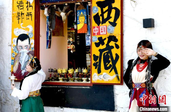 4月17日，游客身著藏式元素服裝在拉薩八廓街拍照留念?！±盍?攝