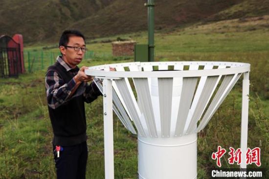 圖為班瑪縣氣象局工作人員在維護(hù)藏雪茶基地氣候站。青海省氣象局供圖