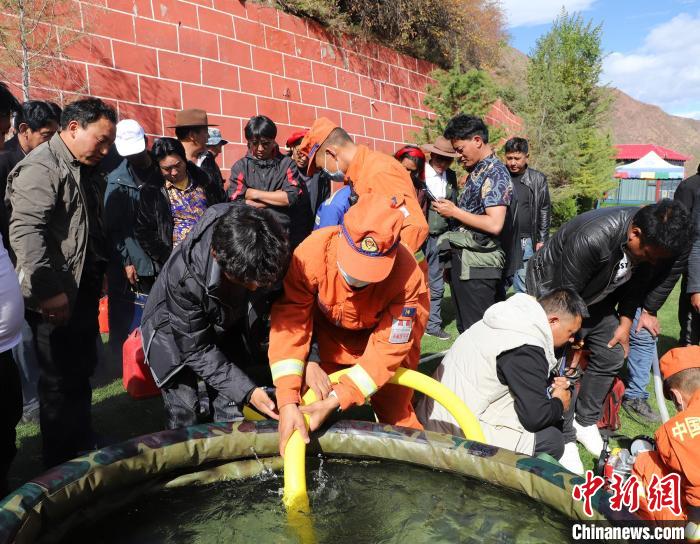 圖為森林消防員為護(hù)林員講解滅火裝備的使用方法。　昌都市森林消防支隊(duì) 供圖