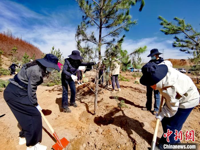 圖為西寧市城東區(qū)干部職工參加義務(wù)植樹?！?zhí)砀?攝