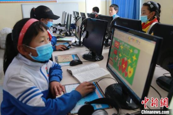 圖為鄉(xiāng)村學校少年宮的孩子們正在上電腦課。　才讓本　攝