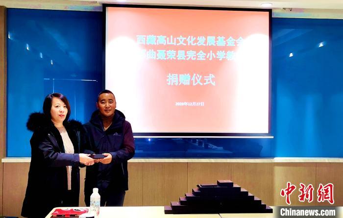 圖為西藏高山文化發(fā)展基金會理事長溫麗向聶榮縣完全小學(xué)負(fù)責(zé)人捐助儀器?！∮谫e 攝