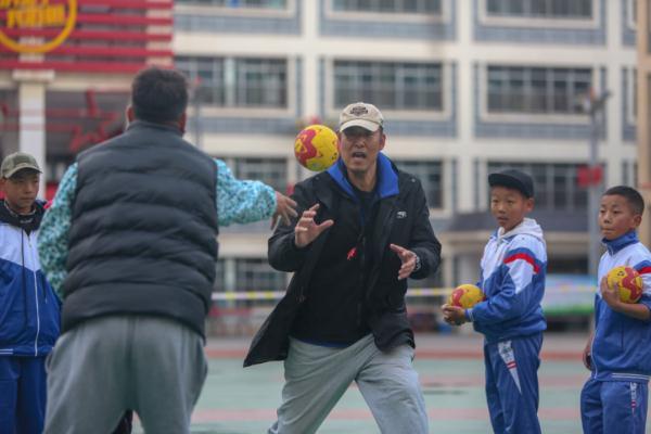 在高原上教孩子們打手球，“慢慢兒來，甭著急！”