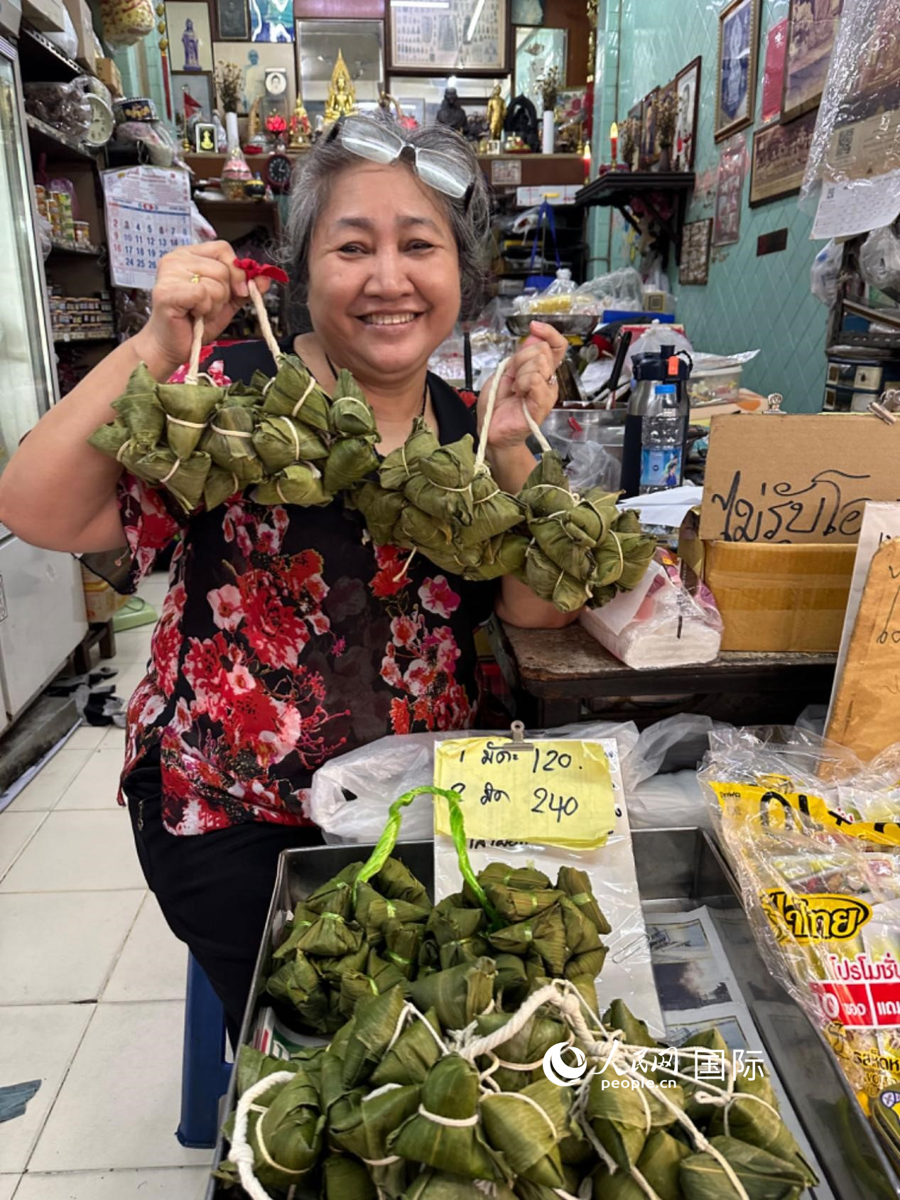 商家向顧客介紹“吉掌”（粽子的一種，一串一串，個(gè)頭較?。Ｈ嗣窬W(wǎng)記者 簡(jiǎn)承淵攝